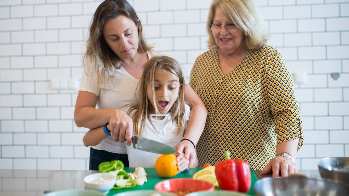 Three generations preparing a meal together in a cozy kitchen setting.
